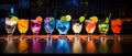 Different tasty cocktails on dark background. Beautiful line of three colorful alcoholic cocktails on a bar in a