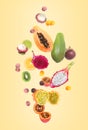 Different tasty exotic fruits flying on yellow background