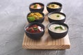 Different tasty sauces in bowls on wooden board