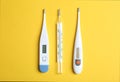 Different thermometers on yellow background