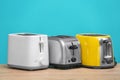 Different toasters on table against color background Royalty Free Stock Photo