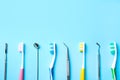 Different toothbrushes and dental tools on light blue background, flat lay. Space for text