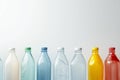 Different transparent plastic bottles on light background. Colorful plastic bottles of various sizes and shapes standing in a row