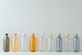 Different transparent plastic bottles on light background. Colorful plastic bottles of various sizes and shapes standing in a row