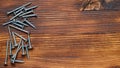 Different type metal screws on wooden background with copy space and top view Royalty Free Stock Photo