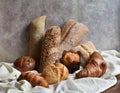 Different types of baking still life. Buns croissants, muffins and loaves, bread patties on textile drapery. Rustic