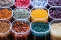 different types of beads, such as wood, plastic, and metal in separate containers