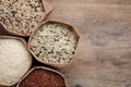 Different types of brown and polished rice in bags on wooden table, flat lay. Space for text Royalty Free Stock Photo