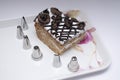 Different types of cake cream nozzels and a cake in a tray Royalty Free Stock Photo