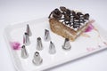 Different types of cake nozzels and a cake in a tray Royalty Free Stock Photo