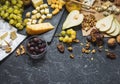 Different types of cheese on board, olive, fruits, almond and wine glasses on black stone table Royalty Free Stock Photo