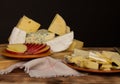 Different types of cheese on a rustic wooden cutting board on a dark background. Copy space Royalty Free Stock Photo