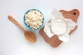 Different types of cheese on white table. Overhead view of cottage cheese and camembert.