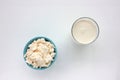 Different types of cheese on white table. Overhead view of cottage cheese, mozzarella, camembert, and milk.