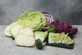 Different types of cut cabbage on light grey table Royalty Free Stock Photo