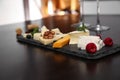 Different types of cheeses with berries and nuts on table Royalty Free Stock Photo