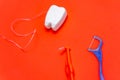 Different types of dental floss and tooth picks on red background. Dental floss in tooth toy shape. Royalty Free Stock Photo