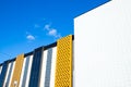 Different types of facade tiles. yellow white gray black generic building facade on blue sky. Office, shopping mall. Pavlodar,