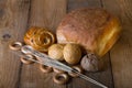 Different types of fresh bread and wheat spikes on old wooden ta