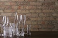 Different types of glasses for cocktails, wine and champagne on the table against brick wall at the bar Royalty Free Stock Photo