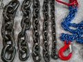 Different types of heavy duty chains and hooks displayed on a gray surface for industrial use Royalty Free Stock Photo