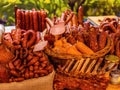 Different types of homemade smoked dry sausages hanging on a dark wooden background. Assortment of delicious deli meats, Salami