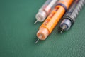 Different types of insulin pens on a green surface Royalty Free Stock Photo