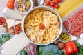 Different types of italian pasta on a wooden background with various ingredients for cooking traditional italian dishes Royalty Free Stock Photo