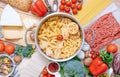 Different types of italian pasta on a wooden background with various ingredients for cooking traditional italian dishes Royalty Free Stock Photo