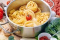 Different types of italian pasta on a wooden background with various ingredients for cooking traditional italian dishes Royalty Free Stock Photo
