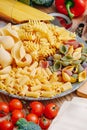 Different types of italian pasta on a wooden background with various ingredients for cooking traditional italian dishes Royalty Free Stock Photo