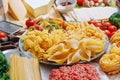 Different types of italian pasta on a wooden background with various ingredients for cooking traditional italian dishes Royalty Free Stock Photo