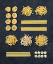 Different types of Italian uncooked pasta on black slate stone background, top view Royalty Free Stock Photo