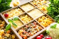 Different types of italian uncooked pasta in wooden box, whole wheat pasta, pasta, spaghetti, noodles, tagliatelle. Top view Royalty Free Stock Photo