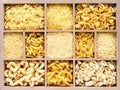 Different types of italian uncooked pasta in wooden box, whole wheat pasta, pasta, spaghetti, noodles, tagliatelle. Top view Royalty Free Stock Photo