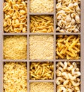 Different types of italian uncooked pasta in wooden box, whole wheat pasta, pasta, spaghetti, noodles, tagliatelle. Top view Royalty Free Stock Photo