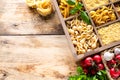 Different types of italian uncooked pasta in wooden box, whole wheat pasta, pasta, spaghetti, noodles, tagliatelle. Top view Royalty Free Stock Photo