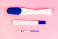 Different types of new pregnancy tests for woman on light pink background. Royalty Free Stock Photo