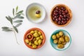 Different types of olives green and black in bowls on white table. Top view, close-up, copy space Royalty Free Stock Photo