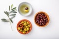 Different types of olives green and black in bowls on white table. Top view, close-up, copy space Royalty Free Stock Photo