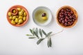 Different types of olives green and black in bowls on white table. Top view, close-up, copy space Royalty Free Stock Photo