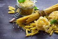 Different types of pasta with basil on the kitchen wooden table. The concept of Italian food