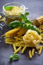 Different types of pasta with basil on the kitchen wooden table. Royalty Free Stock Photo