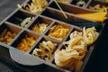 Different types of pasta in a box. Pasta of durum wheat in a box. Fettuccine, spaghetti, farfalle, tagliatelle hard varieties