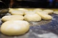 Different types of pizza dough sprinkled with white wheat flour cooking into the grill in food truck.