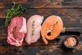 Different types of raw meat steaks Beef striploin, salmon and chicken breast. Dark wooden background. Top view Royalty Free Stock Photo