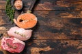 Different types of raw meat steaks Beef striploin, salmon and chicken breast. Dark wooden background. Top view. Copy Royalty Free Stock Photo