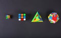 Different types of rubik`s cube on black background. Different difficulty puzzles.Top view with copy space, flat lay
