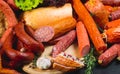 Different types of sausages and meat products on a black background.