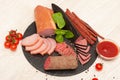Different types sliced sausage on a graphite board with ketchup. top view Royalty Free Stock Photo